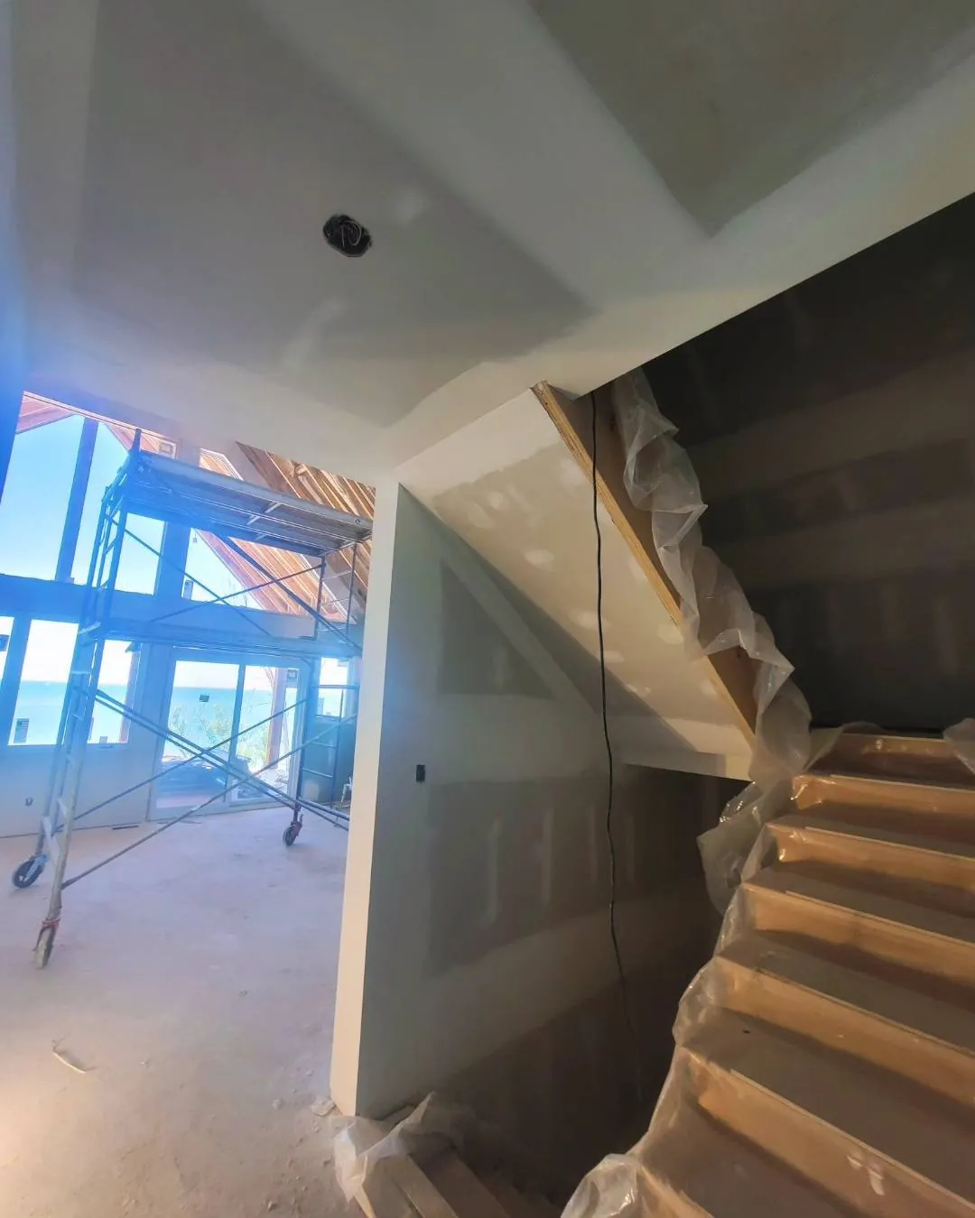 Drywall taping around an open staircase in Hamilton
